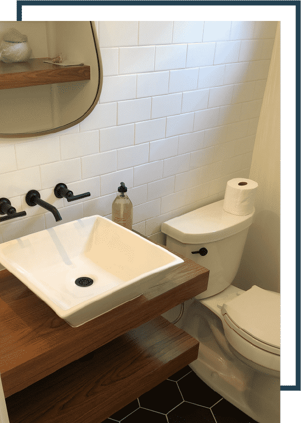 white sink above a wooden cabinet, next to a white porcelain toilet