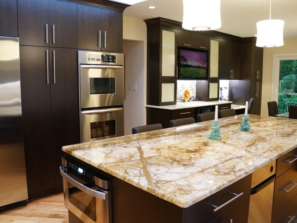 marble topped kitchen table, in the middle of the kitchen surrounded by furnished room.