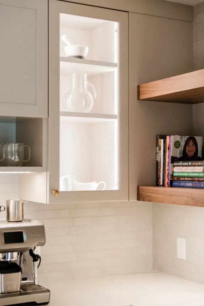 Glass-front cabinetry and wood shelving detail in the Edenderry home in Northville, Michigan