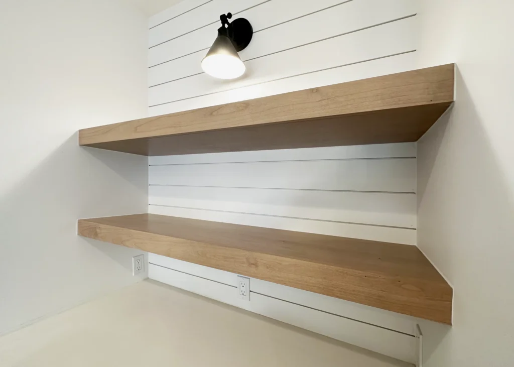 Wood floating shelf detail against white shiplap in Cowdin’s York custom home in Plymouth