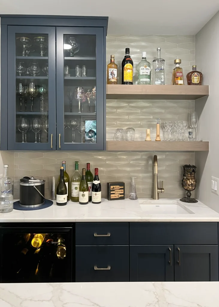 Home bar with dark base cabinetry, open shelves and glass-front display storage.